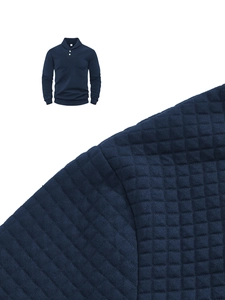 Detail of navy men's knit shirt showing quilted square texture and polo button collar