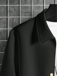 Detail of black quilted jacket showing geometric textures and herringbone fabric pattern