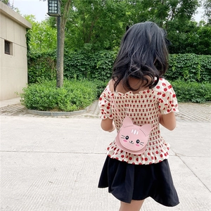 Pink cartoon cat-shaped crossbody bag for girls worn by a child in a sunny park