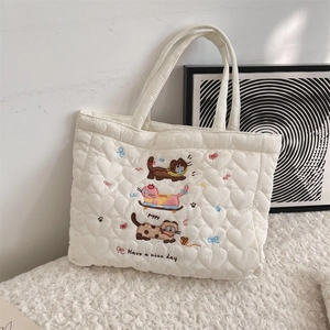 Détail du sac cabas matelassé blanc avec broderie chat mignonne et texture à cœurs