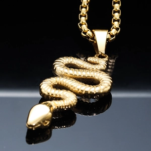 Gilded punk snake pendant on box chain with sleek reflection on black background
