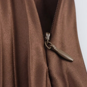 Detail showing high-quality hidden zipper closure on dark brown satin midi skirt