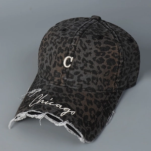 Detail of embroidered Chicago text and metal letter C on leopard print baseball cap