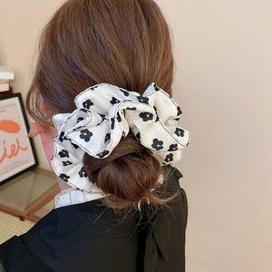 Detail of floral oversized scrunchie in black and white satin on a ponytail