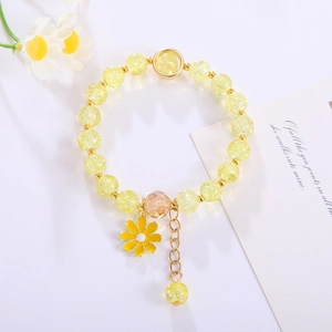 Macro detail of handmade beaded bracelet with yellow crackle crystal and sunflower charm
