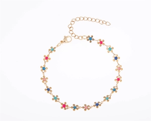 Détail des breloques fleurs en émail coloré sur un bracelet chaîne dorée ajustable