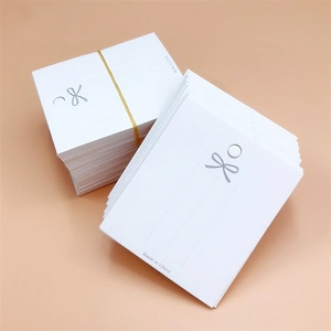 White jewelry display card with silver bow pattern for earrings and necklace packaging