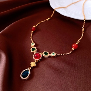 Macro detail of vintage gold necklace with colorful zircon gemstones on silk