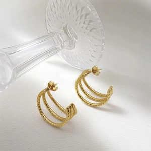 Elegant gold layered hoop earrings with textured finish on a clean white surface