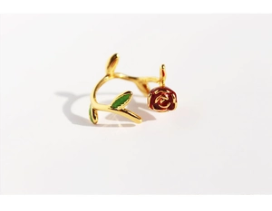 Detail of handmade red enamel rose and green leaves on an adjustable gold flower ring