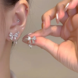 Detailed view of silver butterfly stud earrings with heart stone and star charms