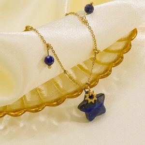 Elegant gold necklace with blue lapis star pendant on silk textured background