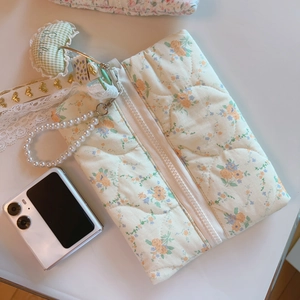 Quilted floral makeup bag with pearl handle and heart pendant, lifestyle view
