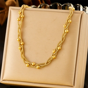 Gold-plated stainless steel multi-layer chain necklace with beads on a display pad