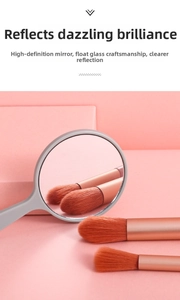 Detail showing high-definition handheld mirror and premium makeup brush set with metal handles