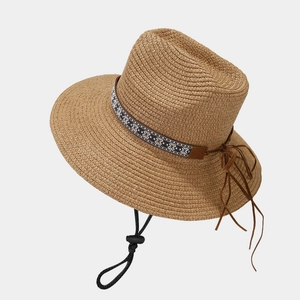 Retro brown straw cowboy hat with ethnic patterned band and adjustable chin strap