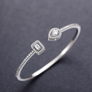 Detailed macro shot of open cuff bracelet with zircon inlays and silver finish