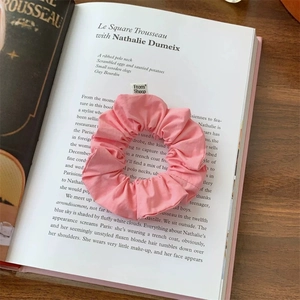 Detail of a pink fabric scrunchie with From Sheep label on an open book page