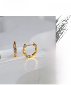 Macro detail of gold-plated brass hoop earrings with double-row micro-pave white zircon stones