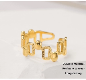 Macro shot of 18k gold plated irregular geometric link ring on white stone surface