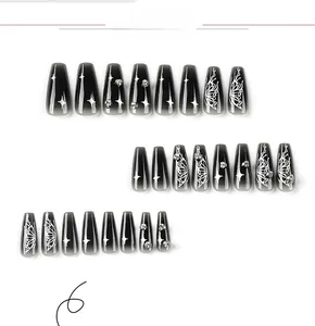 Detail of coffin press-on nails with black cat-eye gradient, silver butterflies and rhinestones