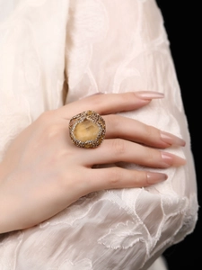 Macro shot of an oversized irregular yellow resin stone ring with crystal accents on a model