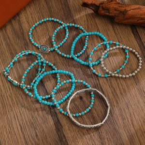 Bohemian turquoise bead and silver alloy bracelet set on rustic wooden background