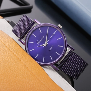 Detail of purple quartz watch with Milanese mesh strap on orange leather backdrop