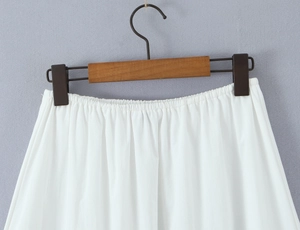Detailed view of elastic waistband on white lace skirt set with light cotton texture