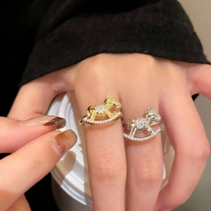 Detailed close-up of gold and silver rocking horse rings with pavé zircon stones