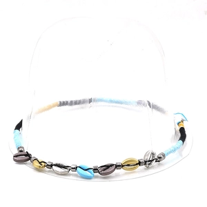 Close-up of ethnic style seashell beaded hat band with colorful shells and metallic beads