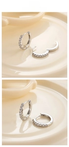 Detail of silver huggie earrings with pave cubic zirconia in open and closed states