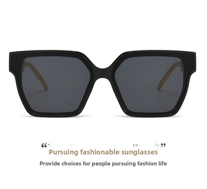Close-up of square frame sunglasses featuring golden chain temples and dark lenses