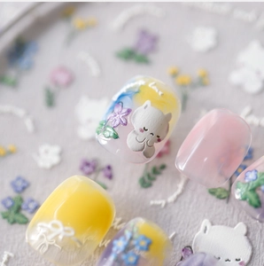 Detailed macro view of 3D embossed nail art stickers featuring cute cat and floral designs