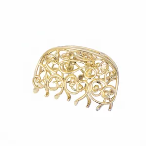 Golden hollow butterfly metal hair claw clip with vintage filigree design on white background