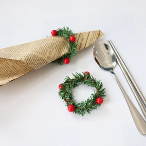 Serviettenring-Set zu Weihnachten mit grünen Kiefernnadeln und roten Beeren für den Tisch