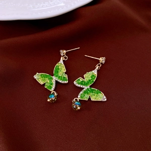Detail of green butterfly drop earrings with rhinestones and iridescent beads