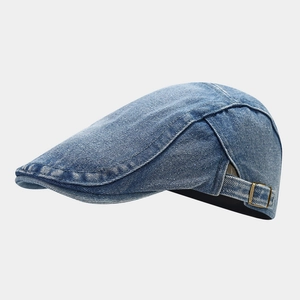 Detailed close-up of blue washed denim beret texture with vintage copper metal buckle