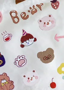 Detailed macro view of cute bear and cartoon nail art stickers with glitter finish