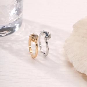 Detail of sun and moon rings with sparkling crystals on a textured surface