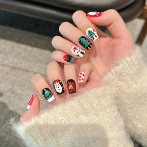 Christmas press-on nails featuring Santa, snowman, and reindeer art on red and green base