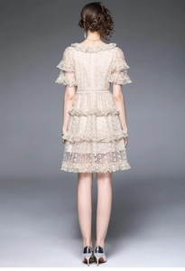 Detail of champagne lace dress with layered ruffle skirt and back waist silhouette