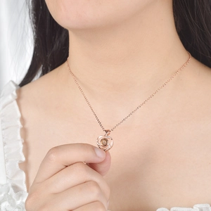 Detail of rose gold heart pendant with projection stone worn on model neck