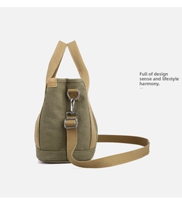 Close-up of olive green and khaki canvas tote with metal buckles and adjustable strap