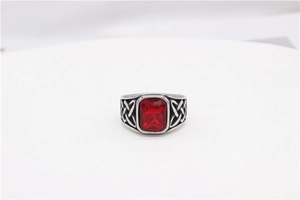 Detail of vintage Celtic knot engraving on a silver steel ring with red stone