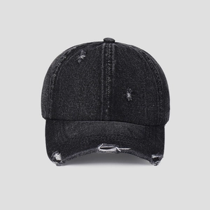 Detailed view of the distressed denim baseball cap showing raw edges and washed texture