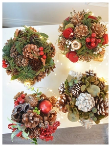 Detail of elegant gold-tone pine cones and red berries for Christmas tabletop decor