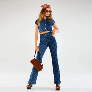 Détail du jean évasé à taille haute et du haut en denim imprimé assorti en bleu rétro