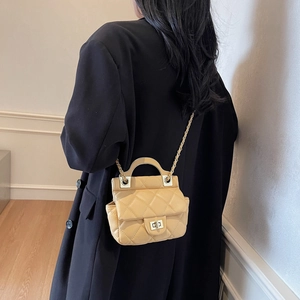 Elegant beige quilted mini handbag with chain strap and metal lock shown on model