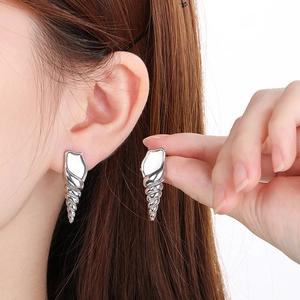 Close-up of silver conch shell earrings with shell inlay and textured metallic finish